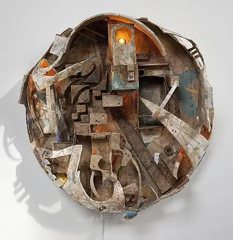 Abstract circular sculpture with layered mixed media.