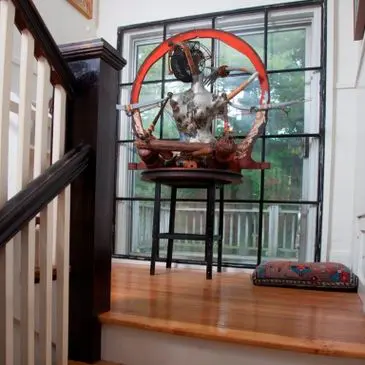 Decorative sculpture by window on staircase landing.