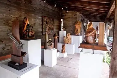 Outdoor wooden sculpture gallery with various pieces.