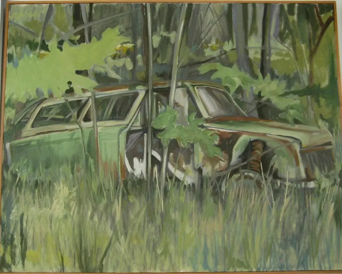 Old car overgrown with forest vegetation.