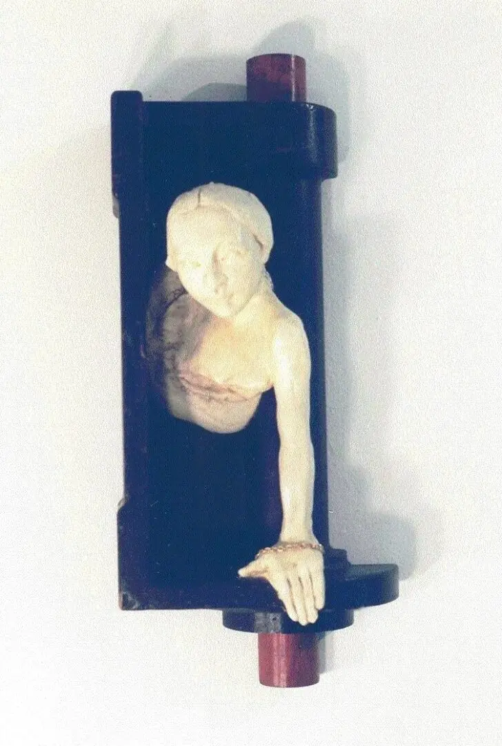 Sculpture of a figure emerging from frame.