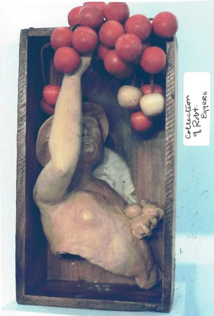 Sculpture of person reaching for hanging fruit.