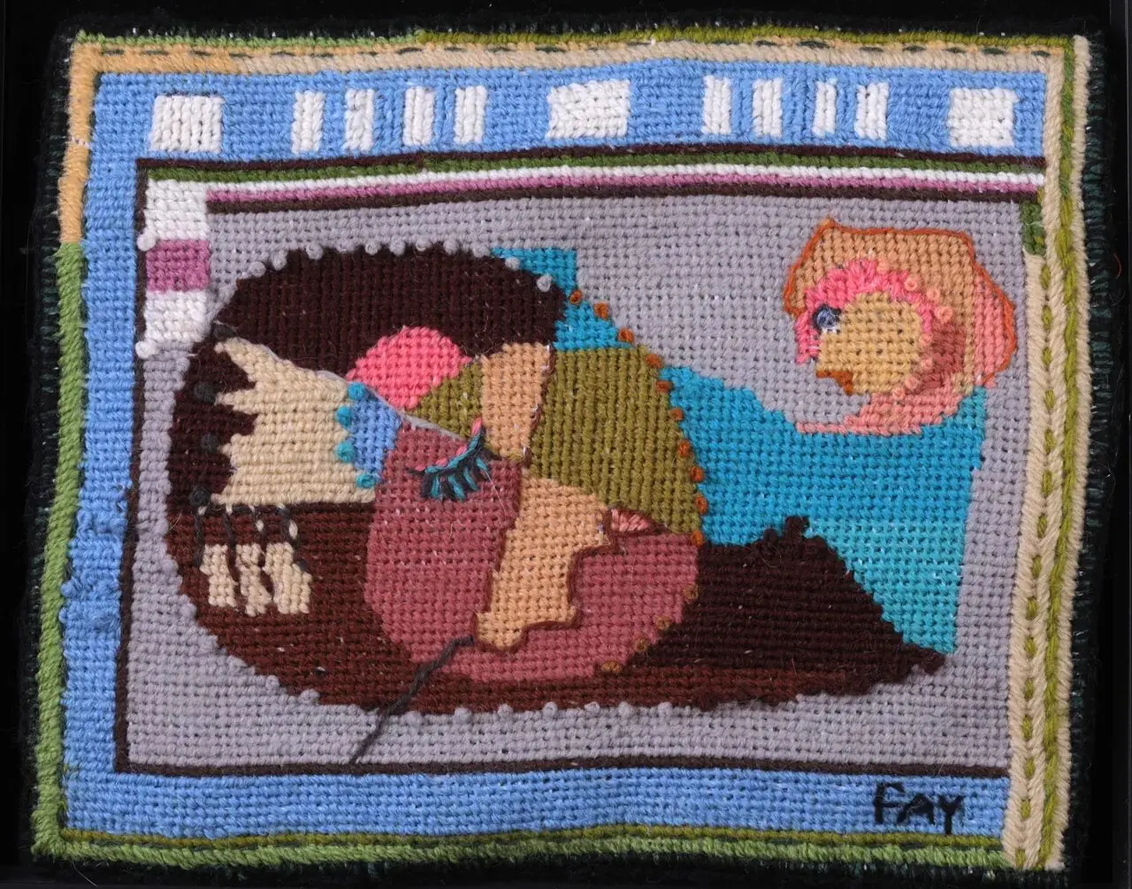 Abstract needlepoint art with colorful geometric shapes.