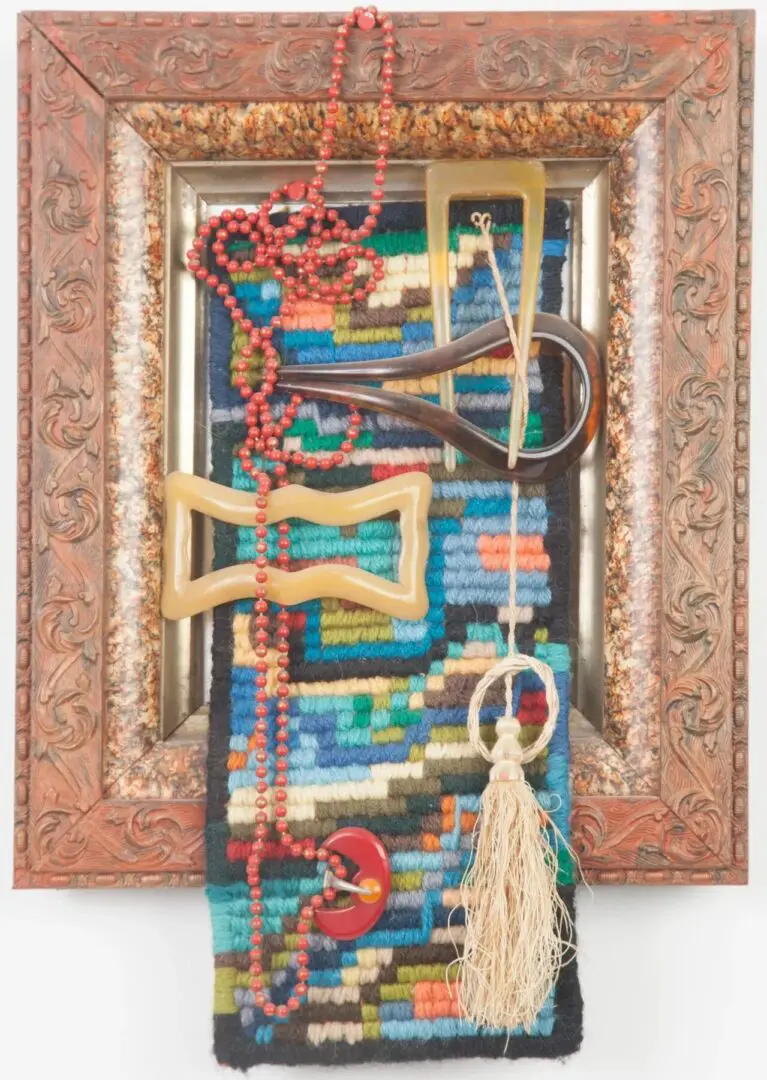 Framed textile art with colorful beads.