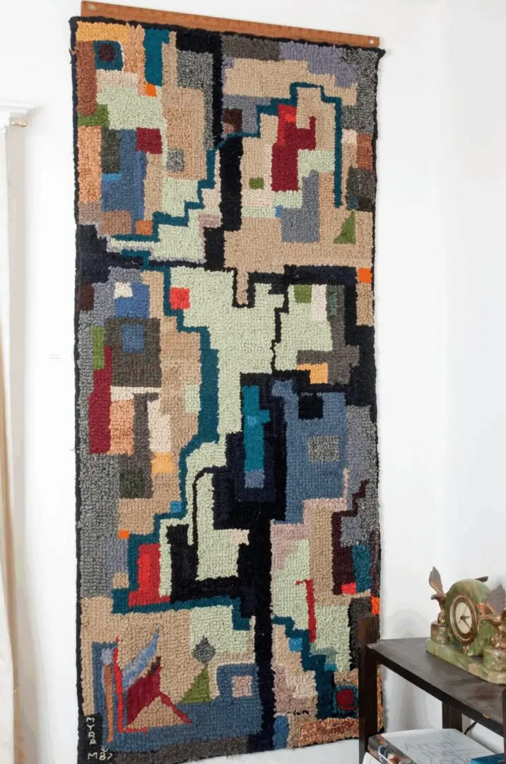 Abstract geometric tapestry hanging on wall.