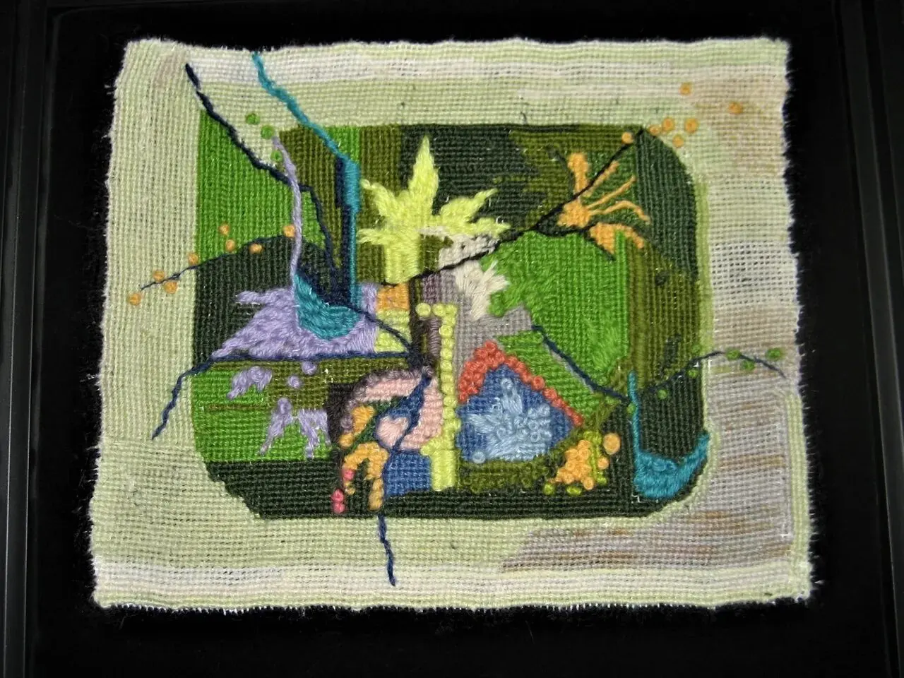 Abstract textile art with colorful geometric shapes.