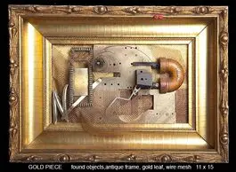 Gold-framed artwork with mechanical components inside.