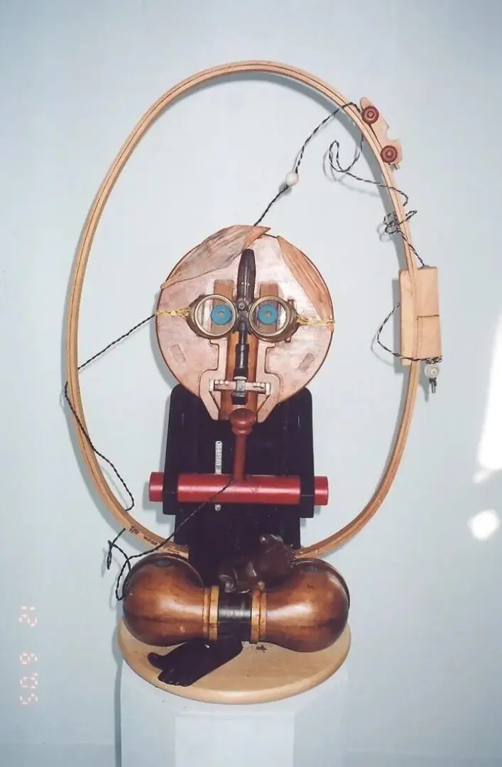 Abstract sculpture with circular frame and objects.