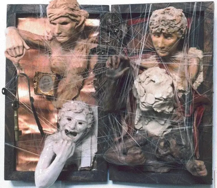 Two ancient stone statues entangled in spider webs.