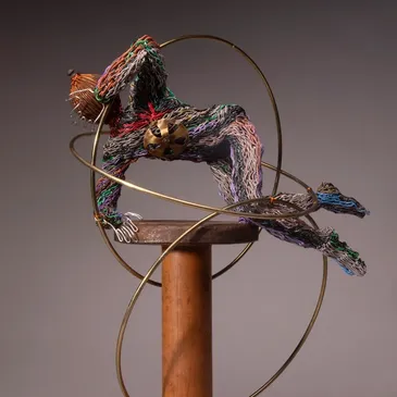Colorful wire sculpture with golden hoops.